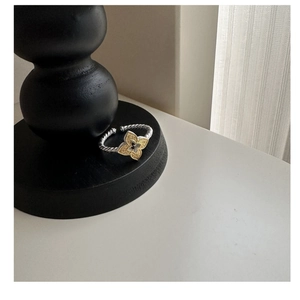 Close-up of S925 sterling silver cable ring with gold flower and black center detail