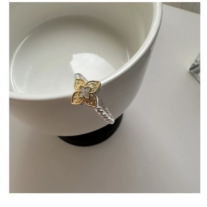 Detail view of silver rope band ring with gold floral clover and white mother of pearl inlay