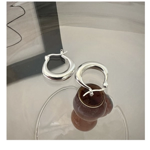 Detail of S925 sterling silver stamp on thick U-shaped polished hoop earring
