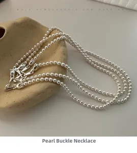 Detail of S925 sterling silver clasp and lustrous white pearls on a ceramic dish