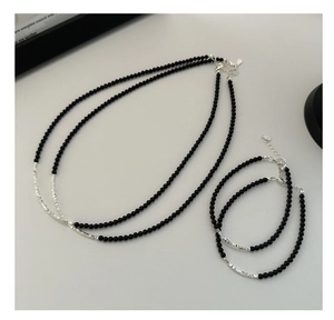 Detail of S925 sterling silver necklace with black agate beads and layered chain design