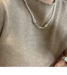 Detail of S925 silver clasp on elegant pearl necklace worn with minimalist silver ring