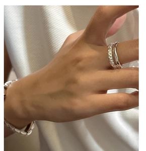 Detail of layered S925 sterling silver hammered texture rings and beaded bracelet set