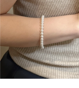 Macro shot of minimalist S925 sterling silver pearl necklace with shiny white beads