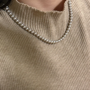 Collier de perles grises à une couche avec fermoir en argent 925 sur pull en maille