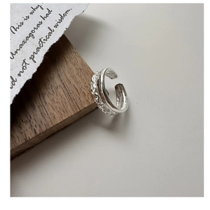 Macro detail of S925 sterling silver double-layered ring with hammered texture finish