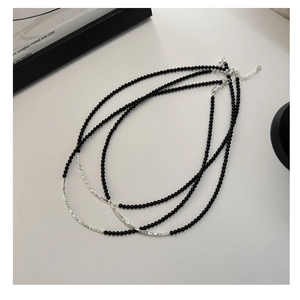 Detailed shot of black onyx beads and silver bar necklace with lobster clasp