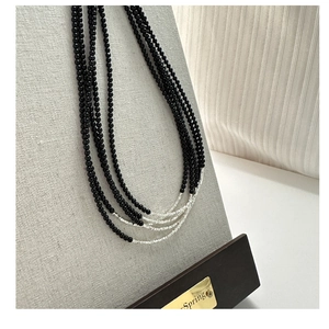 Detail of multi-strand black bead necklace with silver accent on jewelry display