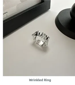 Detailed view of S925 sterling silver ring with irregular crumpled texture and hallmark