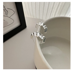 Detail of S925 sterling silver earrings showing irregular texture and silver hallmark