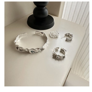 Macro detail of S925 sterling silver jewelry set with minimalist lava texture and hallmarks