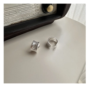 Macro detail of silver rings featuring irregular lava texture and oval cutout design