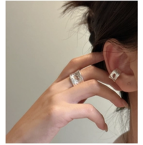 Detailed view of S925 sterling silver ear cuffs with hammered texture and hollow oval design