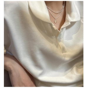 Gros plan sur un collier double épaisseur en argent S925 avec pendentif rond sur mannequin