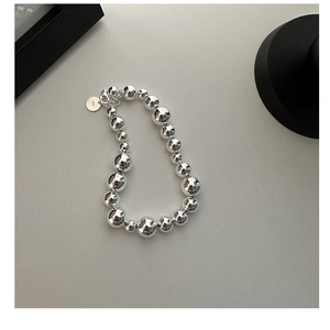 Close-up of S925 sterling silver beaded bracelet showing hallmark tag and polished spheres