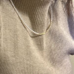 Collana in argento S925 con mezze perle e catena dorata su un maglione beige caldo