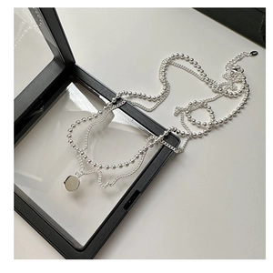 Détail du collier double épaisseur en argent S925 avec pendentif rond sur boîte noire