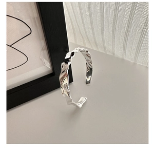 Dettaglio macro del marchio S925 sul bracciale a polsino plissettato e irregolare
