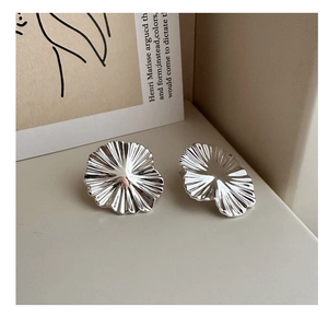 Detailed close-up of textured S925 sterling silver flower earrings on art card