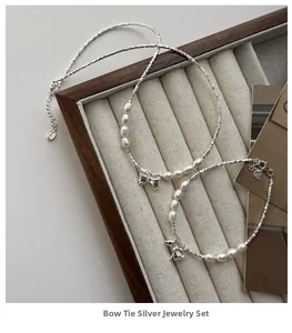 Detail of S925 silver bow jewelry set with baroque pearls on a velvet display tray
