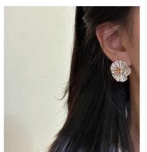 Detailed view of S925 silver large floral earrings featuring unique textured metal pleats