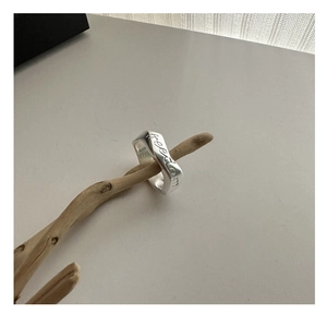 Detailed shot of 925 sterling silver ring with freedom engraving on wood branch