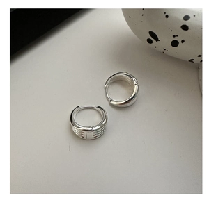 Macro shot of silver minimalist layered hoop earrings with parallel stripe textures