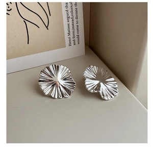 Close-up of S925 sterling silver earrings featuring artistic irregular pleated flower texture