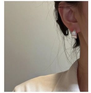 Close-up of S925 sterling silver multi-layered ear cuff with textured vertical stripes