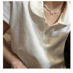 Detail of s925 silver bow pendant on a white pearl necklace and bracelet set