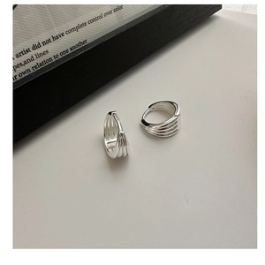 Close-up of polished silver multi-layer hoop earrings with minimalist triple-ring design