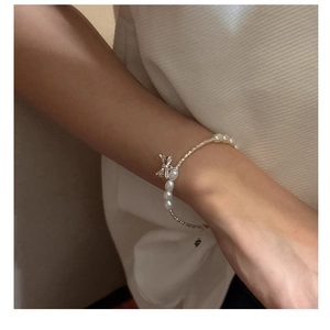 Close-up of pearl bow bracelet with silver beads on wrist for an elegant look