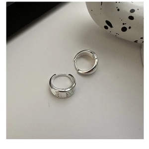Macro detail of S925 sterling silver multi-layered hoop earrings with textured finish