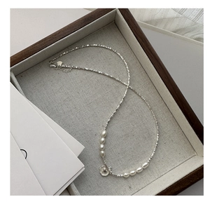 Détail du collier cœur en argent S925 avec perles élégantes sur un plateau en velours