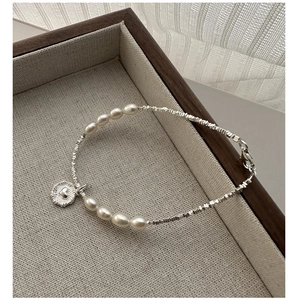 Détail du pendentif cœur en argent sur un bracelet de perles et de billes d'argent