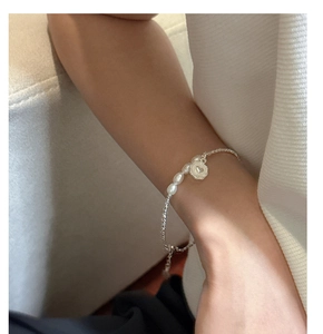 Détail du bracelet en perles d'argent avec perles d'eau douce et pendentif cœur au poignet