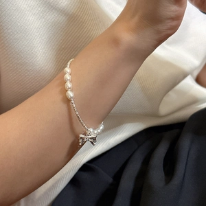 Handmade S925 sterling silver bow bracelet with white pearls and silver beads on wrist