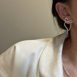 S925 sterling silver bow earrings with hammered texture shown on model in a close-up view