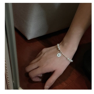 Détail du bracelet en perles d'argent S925 avec pendentif cœur sur le poignet