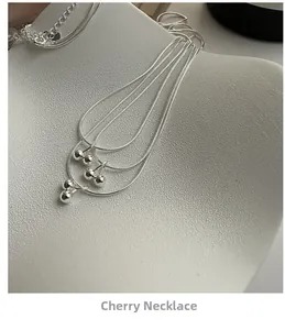 Detailed view of 925 sterling silver cherry pendant necklace on minimalist display