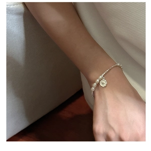 Vue détaillée d'un bracelet en argent S925 avec perles et pendentif rond à lettre V