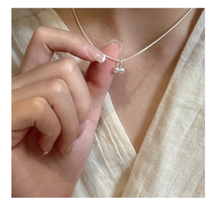 Close-up of minimalist 925 silver necklace with double-ball cherry style pendant for women