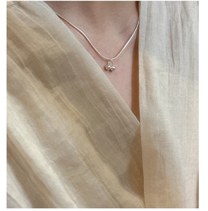 Close-up of minimalist 925 sterling silver cherry pendant necklace on model clothing