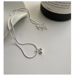 Detailed macro view of 925 sterling silver snake chain with dual sphere pendant charms