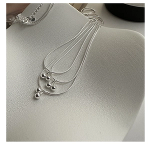Macro shot of 925 silver cherry pendant necklace with polished spheres on snake chain