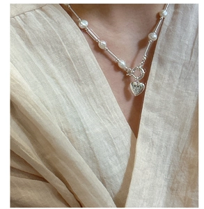Close-up of S925 silver heart pendant with star engraving and pearl splicing necklace