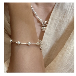 Detailed close-up of S925 sterling silver heart pendant and freshwater pearl necklace