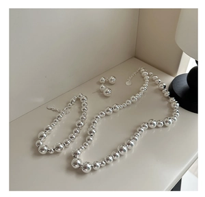 Polished silver bead jewelry set featuring minimalist necklace, bracelet and stud earrings