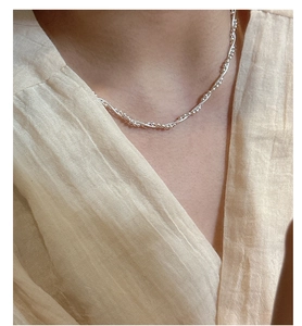 Close-up of double-layered silver snake chain necklace with beads on woman neck