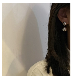 Close-up of minimalist S925 sterling silver double ball drop earrings on model ear